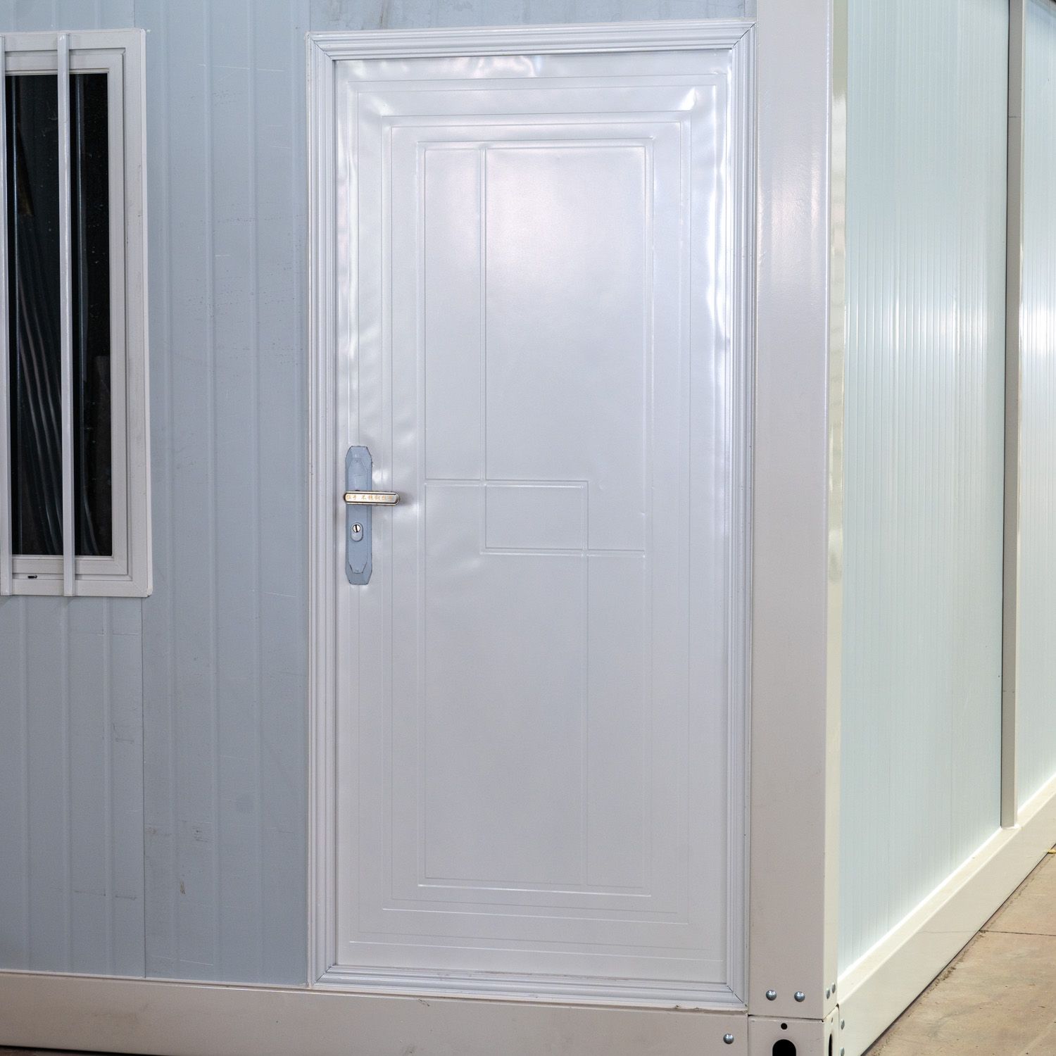 Supplier-provided sample modular unit showing a light-gray wall, white door and white trim